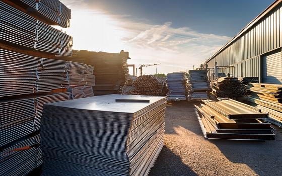 truck with crane working near tall building urban construction site